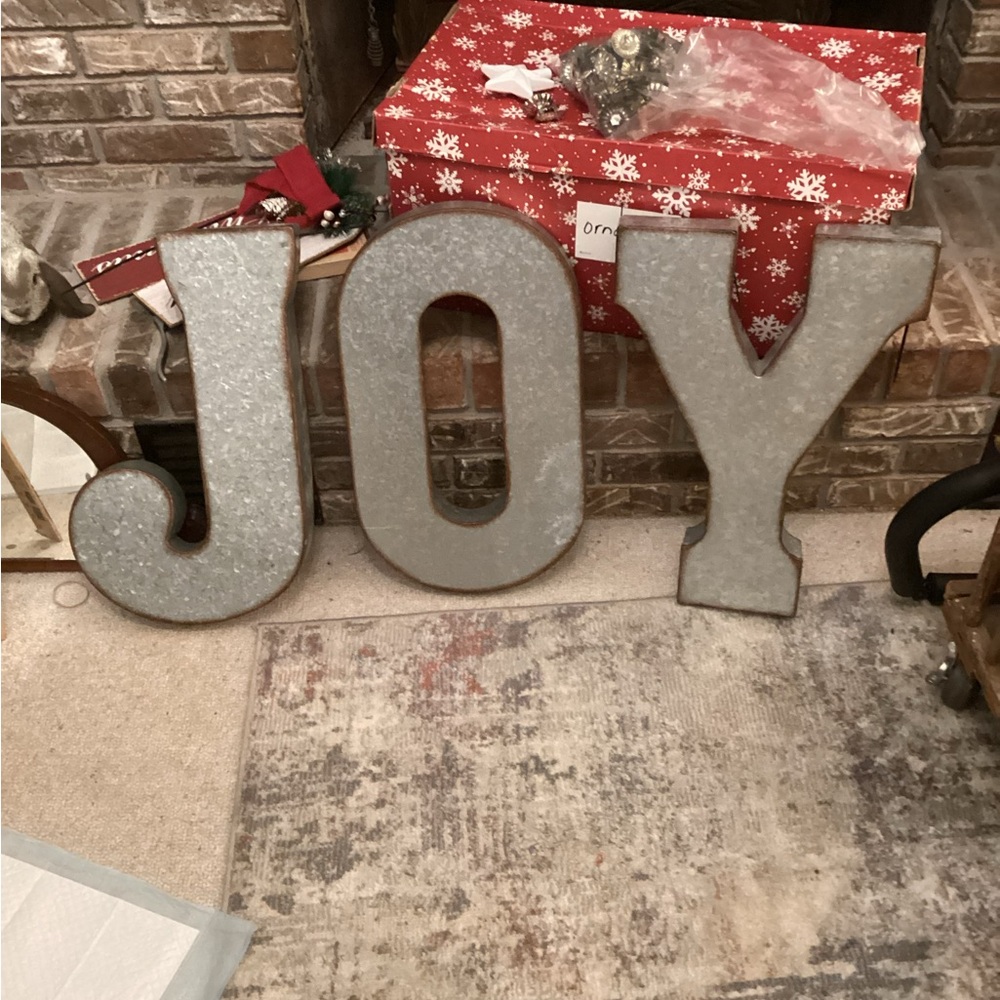 Galvanized letters that spell JOY